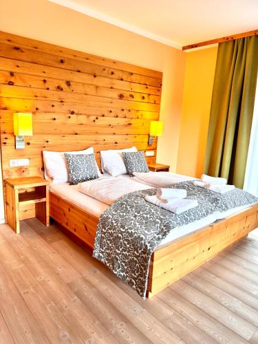 a bedroom with a large bed with a wooden wall at Das Alpl Resort in Krieglach
