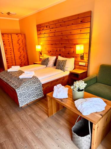a bedroom with a bed and a couch and a table at Das Alpl Resort in Krieglach