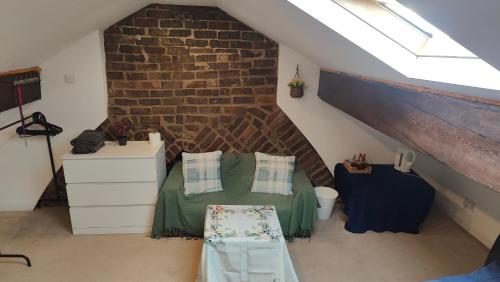 a attic room with a bed and a brick wall at Edwardian House in Manchester