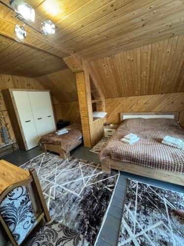 two beds in a room with wooden ceilings at Berizka in Yaremche
