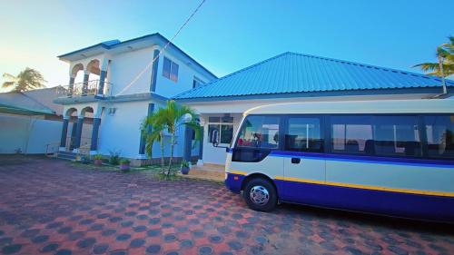 a blue and white bus parked in front of a house at Chibuba Airport Accommodation in Dar es Salaam