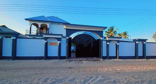 a blue building with a gate on the beach at Chibuba Airport Accommodation in Dar es Salaam
