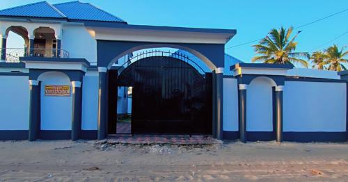a blue building with a large black door at Chibuba Airport Accommodation in Dar es Salaam