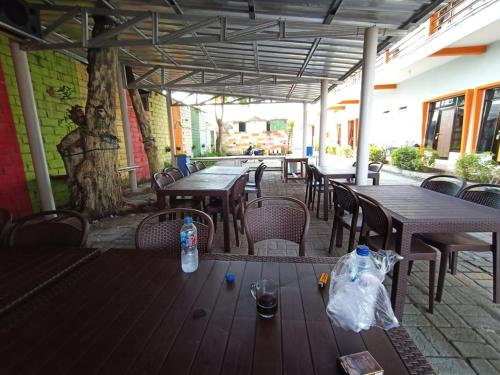 an outdoor patio with tables and chairs with bottles on them at HOMESTAY RJS Pulau Tidung NWR in Pulau Tidung-besar