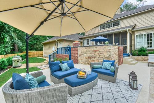 a patio with two couches and an umbrella at New! Pool, Spa, Nature Trails - The Woodlands 4BR Forest Retreat! in Spring