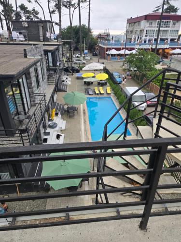 a view of a swimming pool with umbrellas and chairs at Blue Horizon Apartments in Ureki