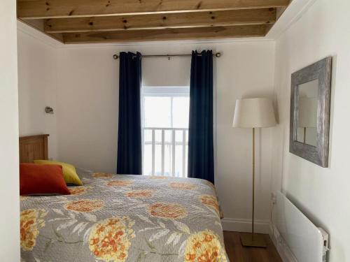a bedroom with a bed with blue curtains and a window at THE LOFT at 5 St Mary's Street Monmouth in Monmouth