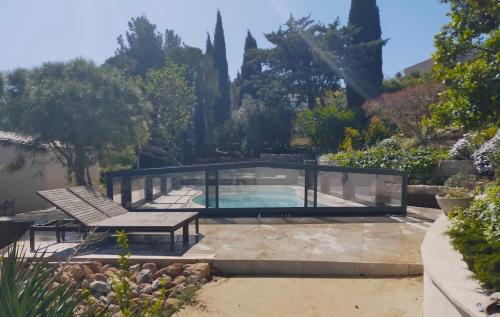 a swimming pool in a garden with a bench at De l'étang de BAGES au massif de la Clape in Narbonne