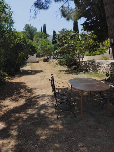 a table and chairs sitting in the shade of a tree at De l'étang de BAGES au massif de la Clape in Narbonne