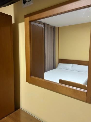 a mirror in a room with a bed in it at Hostal Aeropuerto in Madrid