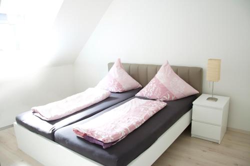 una cama con almohadas rosas en una habitación en Ferienhaus Marina, en Baden-Baden