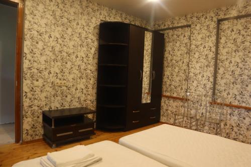 a bedroom with a bed and a black cabinet and a window at Mountain breeze in Lagodekhi
