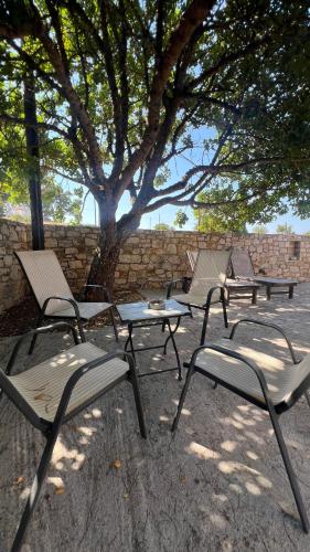 a group of chairs and tables under a tree at KYTHIRA ISLAND RETREAT in Áyios Ilías