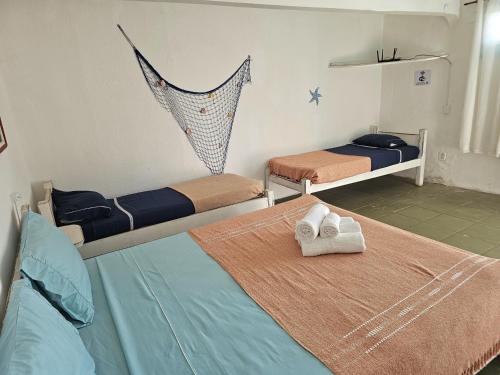 1 dormitorio con 2 camas y hamaca en Pousada Canoa do Mar, en Búzios