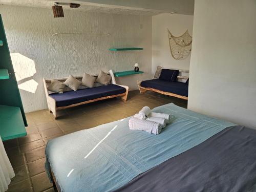 Una habitación con dos camas y un sofá. en Pousada Canoa do Mar, en Búzios