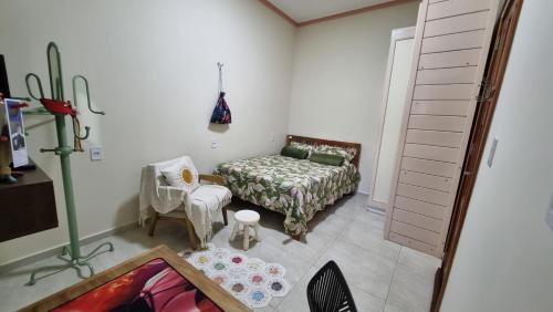 a living room with a bed and a chair at Apartamento funcional próximo ao Shopping Paraíso e comércios in Santarém