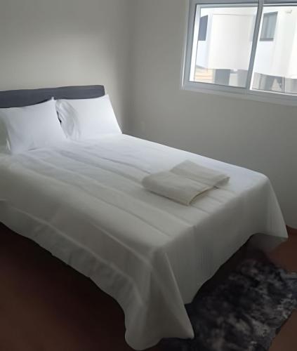 a white bed with white sheets and a window at Apartamento Central com suite Panazzolo 7 minutos do centro in Caxias do Sul