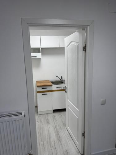 an open door to a kitchen with white cabinets at DS Beauty Center in Drăgăşani