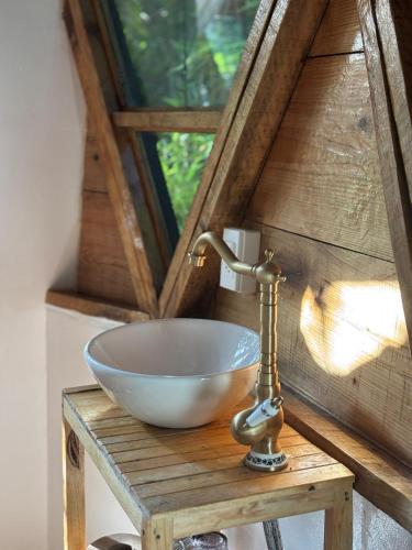 ein Waschbecken auf einem Holztisch mit einem Fenster in der Unterkunft Domo Geodésico en Malinalco in Malinalco