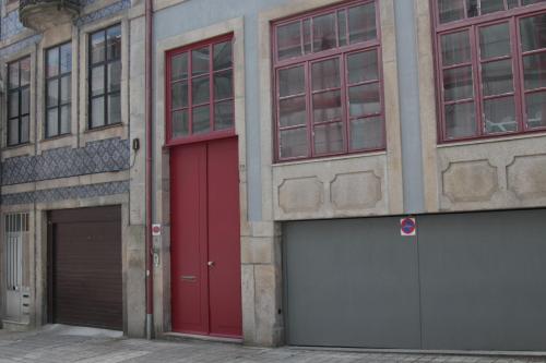 two garages with red doors on the side of a building at Casas do Teatro in Porto