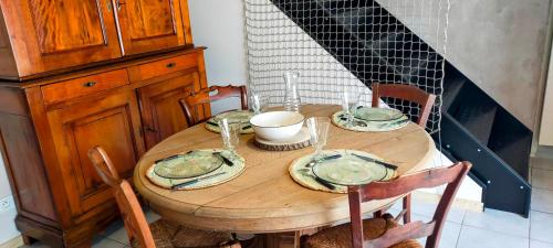 a wooden table with plates and bowls on it at De l'étang de BAGES au massif de la Clape in Narbonne