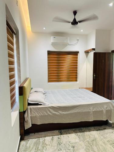 a bedroom with a bed and a ceiling fan at Urban Retreat in Kaniyapuram