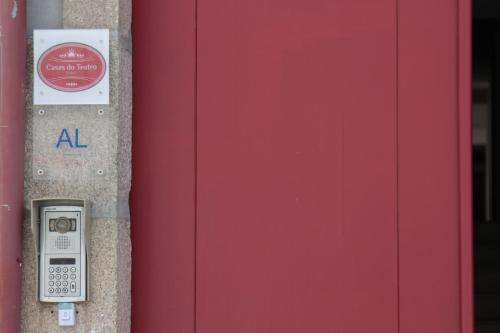 a parking meter next to a red door at Casas do Teatro in Porto