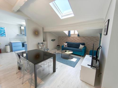 a living room with a blue couch and a table at Location vacances T3 à Cannes in Cannes