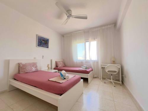 a bedroom with two beds and a ceiling fan at King's Palace nice apartments 2bd, 2bath sea view in Paphos City