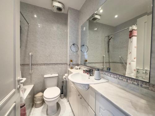 a bathroom with a toilet and a sink and a mirror at King's Palace nice apartments 2bd, 2bath sea view in Paphos City