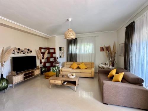 a living room with a couch and a tv at CactusHome in Epanomi