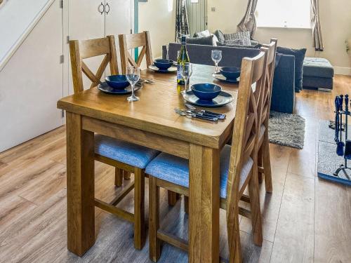 a wooden dining room table with chairs and wine glasses at Willow Cottage in Beverley