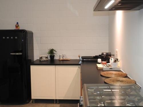 a kitchen with a black refrigerator and a counter at Casa Milo in Lokeren