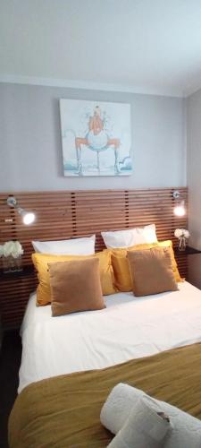 - une chambre avec un grand lit blanc et des oreillers jaunes dans l'établissement appartement la Croix Valmer, à La Croix-Valmer