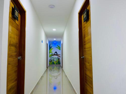 a hallway with two wooden doors and a hallway with white walls at Hotel ESI Apartado in Apartadó