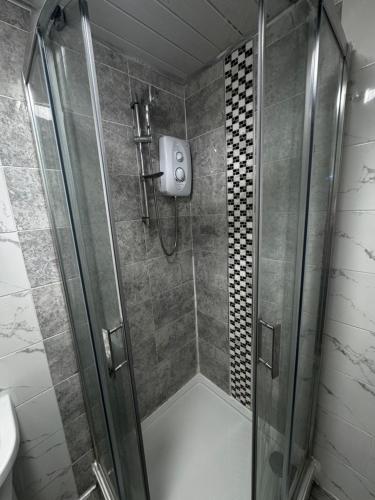 eine Dusche mit einer Glastür in einem Badezimmer in der Unterkunft Bright and spacious home within walking distance to Luton Airport and amenities in Luton