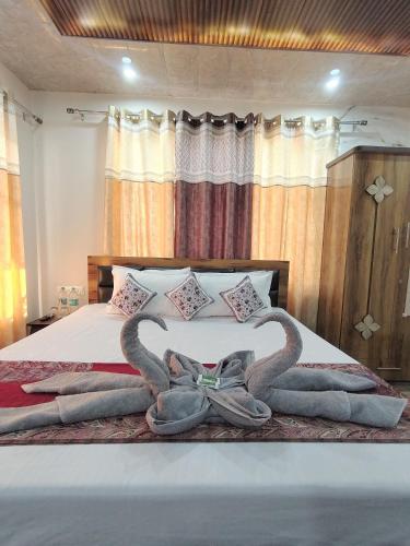 a bed with two swans made out of towels at TreeHouse Kasauli Operated By Splendid Hotels I Vacations I Family Groups & Events I Forest Treks I Memories I in Kasauli