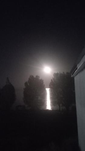 a full moon rising over trees in a foggy night at Moon inn Sevan Resort in Sevan