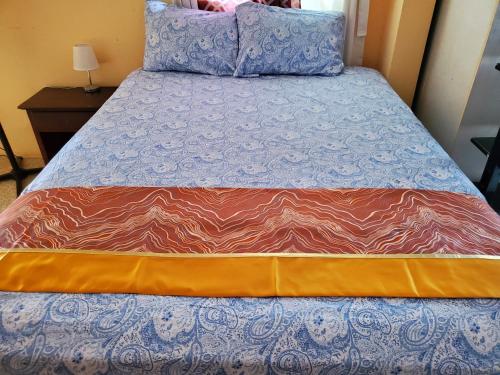 a bed with a blue and orange comforter on it at BAYVIEW LUXURY RETREATS st Jame in Montego Bay