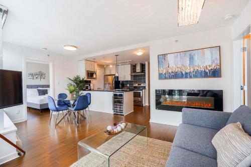 Una sala de estar con un sofá y una mesa con sillas. en Gorgeous Unit with City Views, en Vancouver
