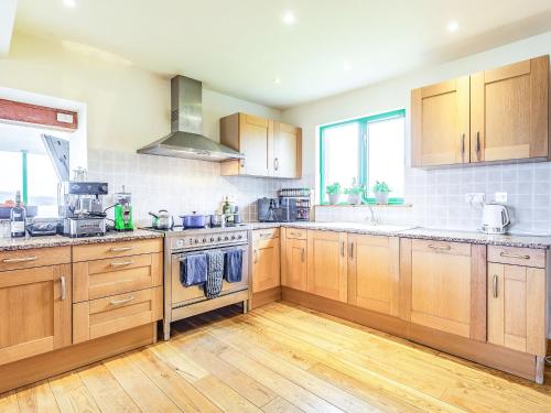 a kitchen with wooden cabinets and wooden floors at Longa House in Big Sand