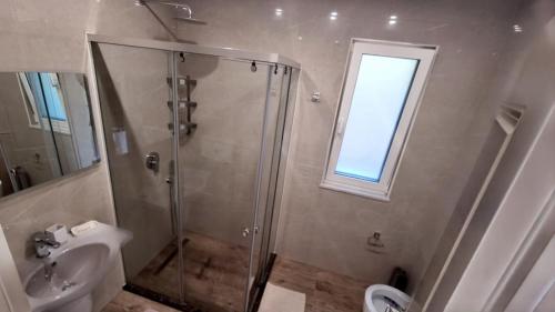 a bathroom with a shower and a toilet and a sink at Villa Amorino by the Sea in Draçi