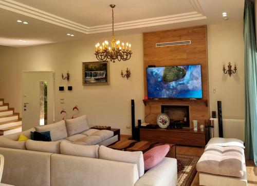 a living room with couches and a tv at Villa Amorino by the Sea in Draçi