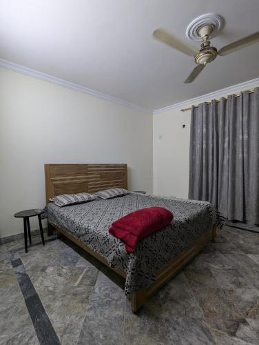 a bedroom with a bed and a ceiling fan at Holiday inn in Islamabad