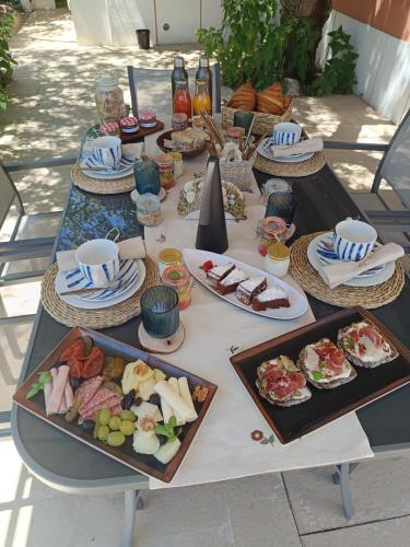 a table with plates of food on it at Casa das Laranjeiras e parque infantil in Villa Nogueira
