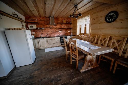 Il comprend une cuisine équipée d'un réfrigérateur, d'une table et de chaises. dans l'établissement Chata Bučina, à Oravská Lesná