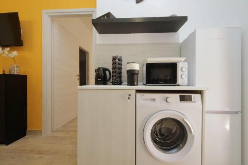 a kitchen with a washing machine and a microwave at Michele Lux Lodge 6 people Spotless and Connected to Airport and Vatican in Rome