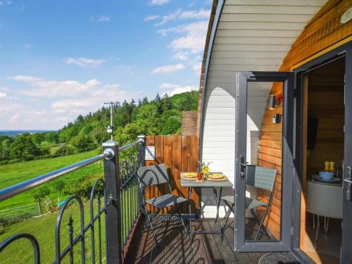 a balcony with a table and chairs on a house at Sunset Holiday Pod - Uk48592 in Church Stretton