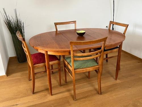 a wooden table with four chairs and a bowl on it at Gästesuiten beim Schloss in Eisenstadt