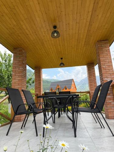 a black dining table and chairs on a patio at Casa KamArea in Stepantsminda